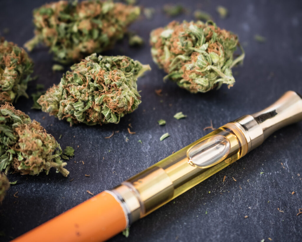 Marijuana buds with a THC oil concentrate filled vape pen
